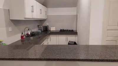 a kitchen with white cabinets and a counter top at Villa Olivia in Seminyak