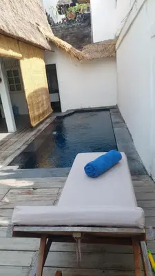a mattress with a blue pillow sitting on top of it at Villa Olivia in Seminyak
