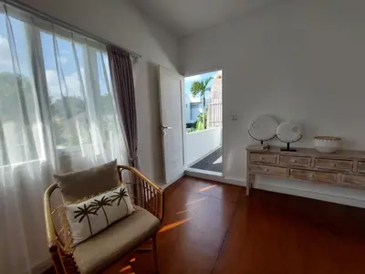 a living room with a chair and a large window at Villa bale villa in Seminyak