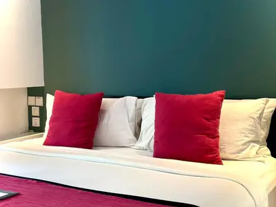 a white couch with three red pillows on it at Villa Harris Canggu in Canggu