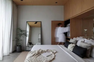 a bedroom with a bed and a person in a mirror at OXO Townhouses Berawa Canggu in Canggu