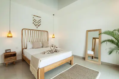 a bedroom with a bed and a mirror at Simple & Magical Villas VILLA SAMBALI in Seminyak