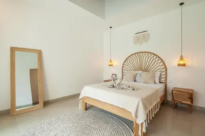 a bedroom with a large bed and a mirror at Simple & Magical Villas VILLA SAMBALI in Seminyak