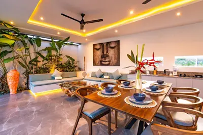 a living room with a table and chairs and a couch at Hedonia Luxury Villas in Seminyak