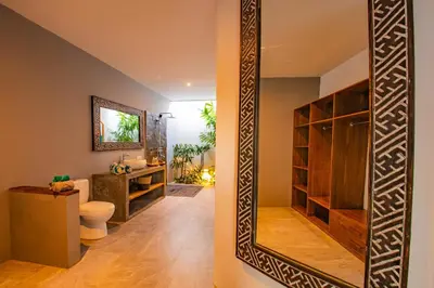 a bathroom with a mirror and a toilet and a sink at Hedonia Luxury Villas in Seminyak