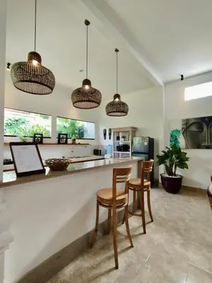a kitchen with a bar with chairs and pendant lights at Villa MONTI - LEGIAN - SEMINYAK - Lovely 2 Bedroom Villa - Great Location ! in Seminyak