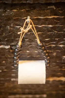 a light with a roll of toilet paper hanging on a wall at Simple And Magical . VILLA ALMAYA in Seminyak