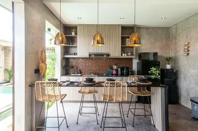a kitchen with a counter and stools in it at Simple And Magical . VILLA ALMAYA in Seminyak