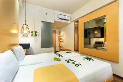 a bedroom with a large white bed with a large mirror at Boss Legian Hotel Powered by Archipelago in Legian