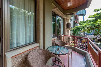 a balcony with chairs and a table and windows at Cozy Bali Apartment in Seminyak