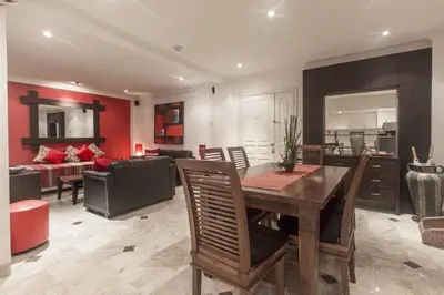 a dining room and living room with a table and chairs at Cozy Bali Apartment in Seminyak
