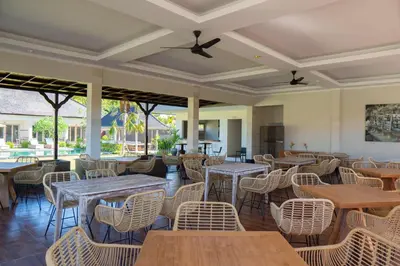 a restaurant with tables and rattan chairs at Green D'mel Bali in Nusa Dua