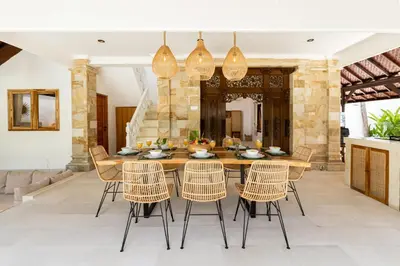 a dining room with a wooden table and chairs at Villa Chandika - 4 BDR Villa with private Pool, walk to the beach in Seminyak