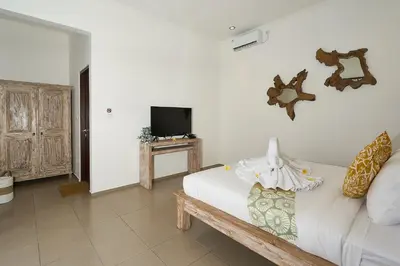 a living room with a couch and a tv at CASA BEGJA I Tranquil 2BR Villa w Private Pool in Mertanadi in Seminyak