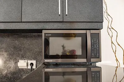 a microwave oven sitting on top of a kitchen counter at Casa Jinah 1 I Simply Modern Twin Villas (2BR) with Private Pool in Seminyak