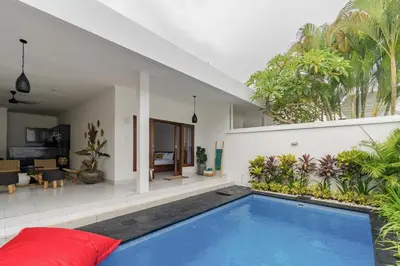a house with a swimming pool and a living room at Casa Jinah 1 I Simply Modern Twin Villas (2BR) with Private Pool in Seminyak