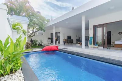 a swimming pool in front of a house at Casa Jinah 2 I Simply Modern Twin Villas (2BR) in Bidadari in Seminyak