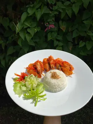 a white plate of food with shrimp and rice at Kusnadi Hotel in Legian