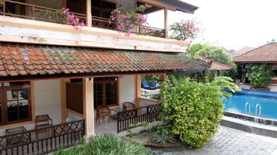 a house with a swimming pool and a patio at Fat Yogi Cottages in Kuta