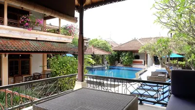 a balcony with a swimming pool on a building at Fat Yogi Cottages in Kuta
