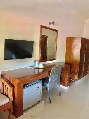 a wooden desk with a mirror and a chair at Fat Yogi Cottages in Kuta