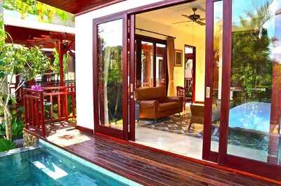 a house with a swimming pool next to a house at Aqua Octaviana Bali Villa in Canggu
