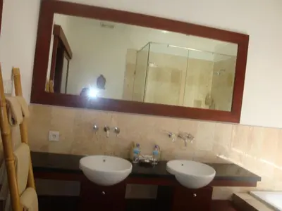 a bathroom with two sinks and a large mirror at Aqua Octaviana Bali Villa in Canggu