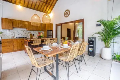 a dining room with a wooden table and chairs at Villa Deba 2 by Bali Villa Solutions in Seminyak