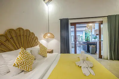 a bedroom with a large white bed with a yellow blanket at Villa Deba 2 by Bali Villa Solutions in Seminyak