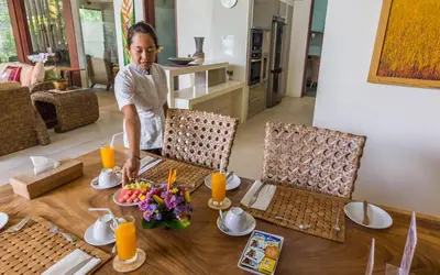 a woman standing in front of a table with food at Villa Lisha in Canggu
