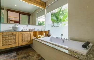 a bathroom with a large tub and a sink at Villa Lisha in Canggu