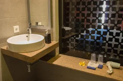 a bathroom with a sink and a shower at Natya Hotel Kuta in Kuta
