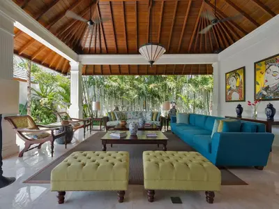 a living room with a blue couch and chairs at Villa Windu Asri in Seminyak