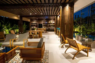 a resort lobby with chairs and tables and a pool at Tanaga CoLiving in Seminyak