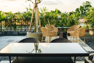 a table and chairs on a patio with trees at Tanaga CoLiving in Seminyak