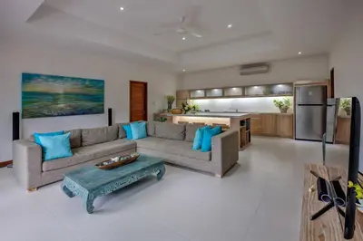 a living room with a couch and a table and a kitchen at Central Seminyak, 3BR, Ensuites, Sleep 6, Peaceful in Seminyak