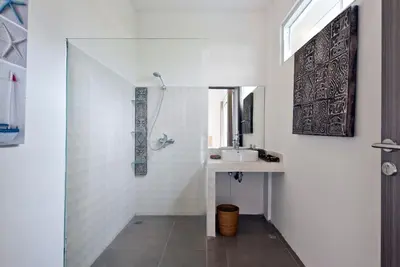 a white bathroom with a sink and a mirror at 3BR Del Mar Beach Villas Near La Plancha Seminyak in Seminyak