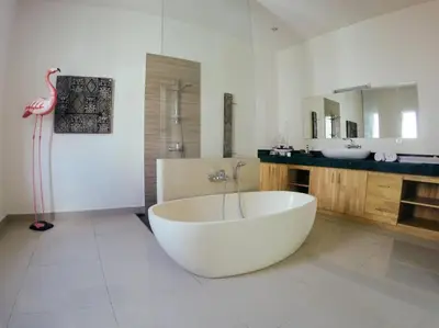 a bathroom with a large white tub and a pink flamingo at 3BR Del Mar Beach Villas Near La Plancha Seminyak in Seminyak
