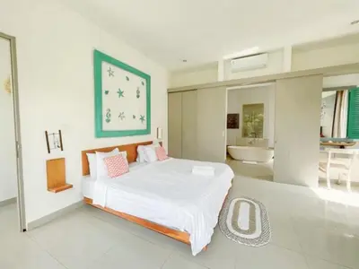 a bedroom with a large bed and a bathroom at 3BR Del Mar Beach Villas Near La Plancha Seminyak in Seminyak