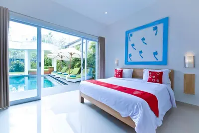 a bedroom with a large bed and a swimming pool at 3BR Del Mar Beach Villas Near La Plancha Seminyak in Seminyak