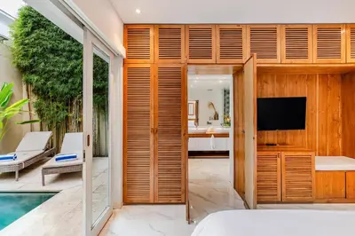 a bedroom with a television and a pool at Villa Vana, Sitara Villa Group in Seminyak