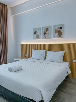 a bedroom with a large white bed with two pillows at Olivia SOHO Guest House in Legian