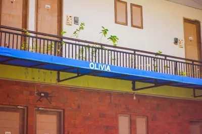 a blue balcony on the side of a building at Olivia SOHO Guest House in Legian