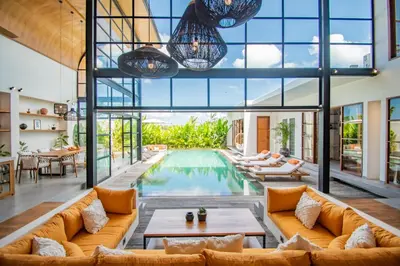 an open living room with a pool and large windows at Villa Mango 2 - Amazing 4-bdr Villa in Berawa ! PERFECT LOCATION in Canggu