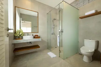 a bathroom with a shower and a toilet and a sink at Villa Christie By Nakula in Seminyak