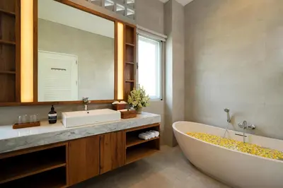 a bathroom with a tub and a sink and a mirror at Villa Christie By Nakula in Seminyak