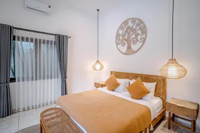 a bedroom with a bed and a window and pendant lights at Villa Deba 3 by Bali Villa Solutions in Seminyak
