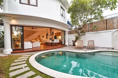 a swimming pool in front of a house at Villa Kalita Bali in Seminyak