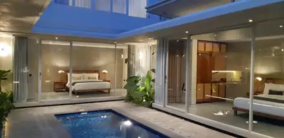 a bedroom with a bed and a swimming pool at Villa Mandja - Stunning architect-designed 3BR villa in Petitenget in Seminyak