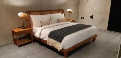 a bedroom with a large bed with two lamps on tables at Villa Mandja - Stunning architect-designed 3BR villa in Petitenget in Seminyak